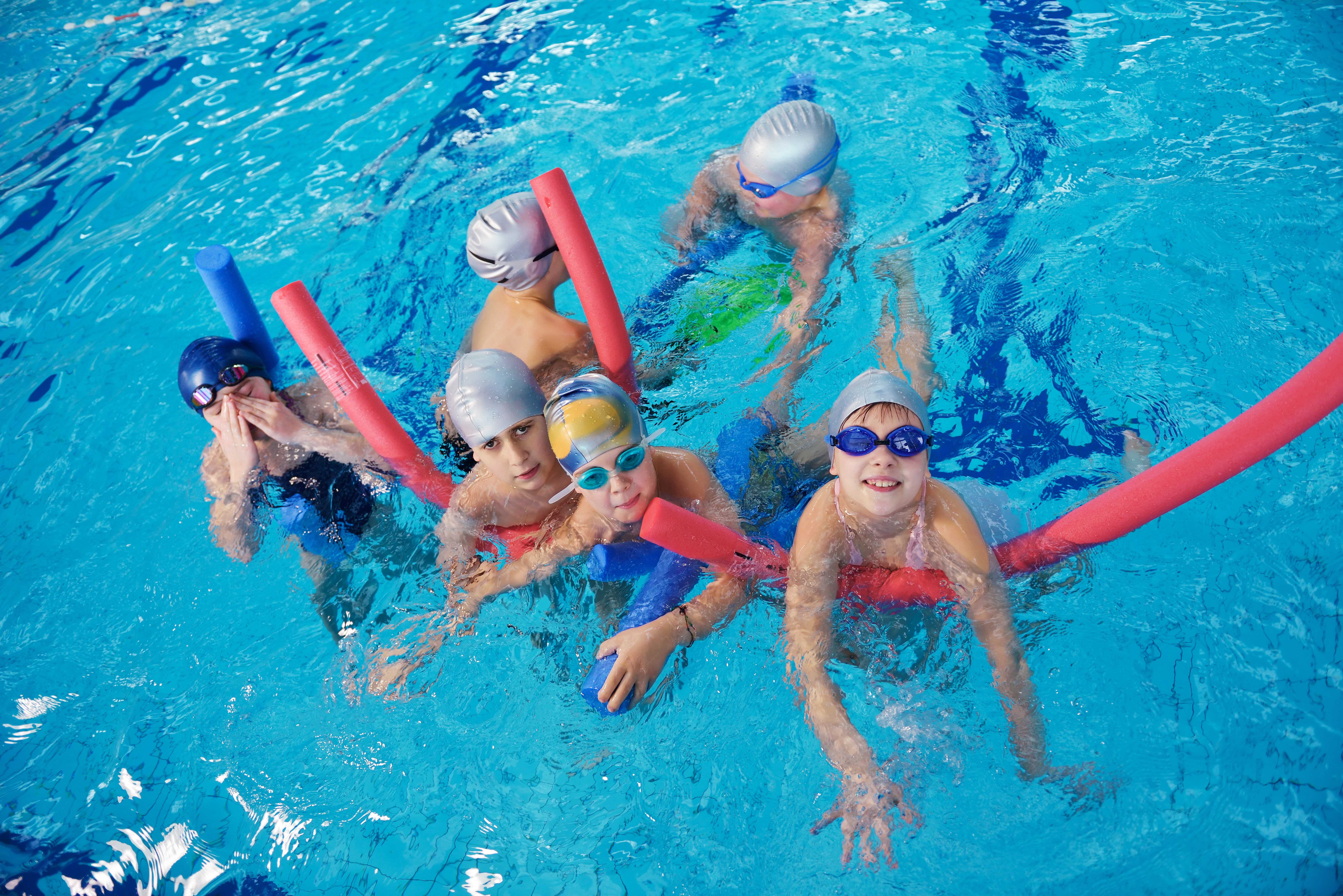 happy children kids group  at swimming pool class  learning to swim